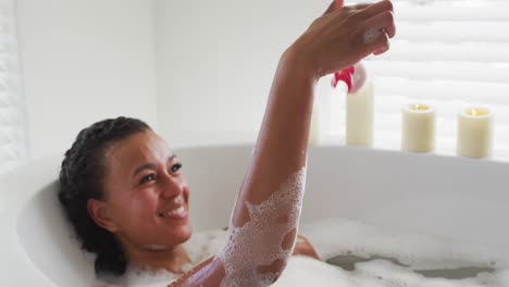 Afroamerikanische-Frau-Spielt-Mit-Rosenblättern-In-Der-Badewanne-Im-Badezimmer-Zu-Hause