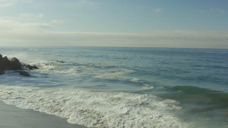 Tilt-shot-view-of-beautiful-beach-with-cliff