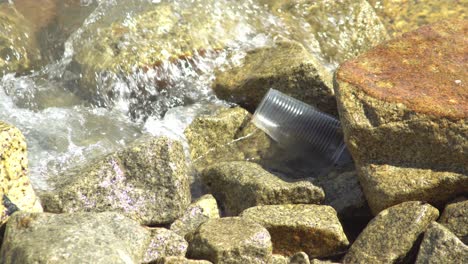 Plastic-cup-hit-by-wave-and-stuck