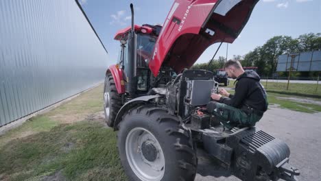 farmer mechanic repairing tractor. open tractor hood, engine. repair agricultural technology