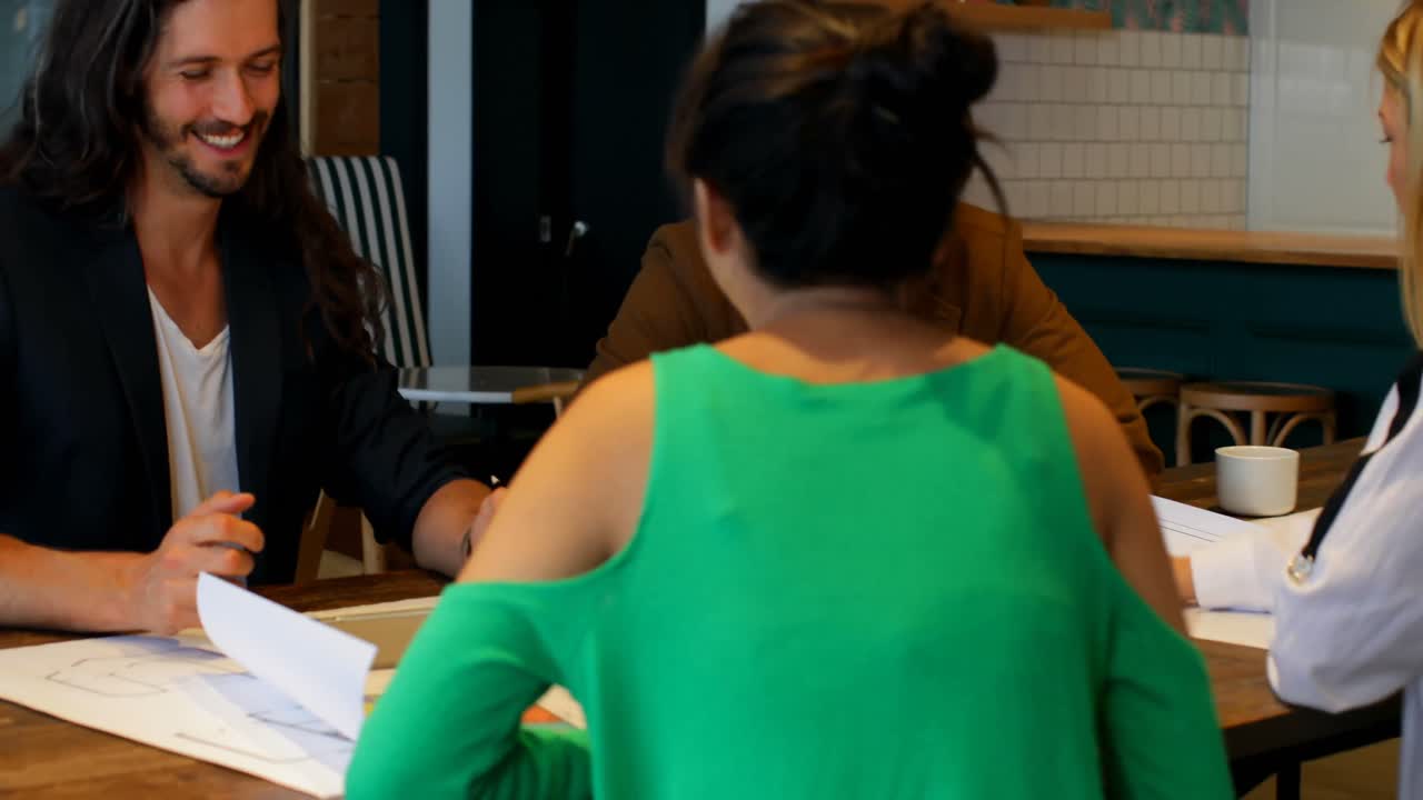 비즈니스 동료들이 사무실 4k에서 청사진을 논의하고 있습니다.