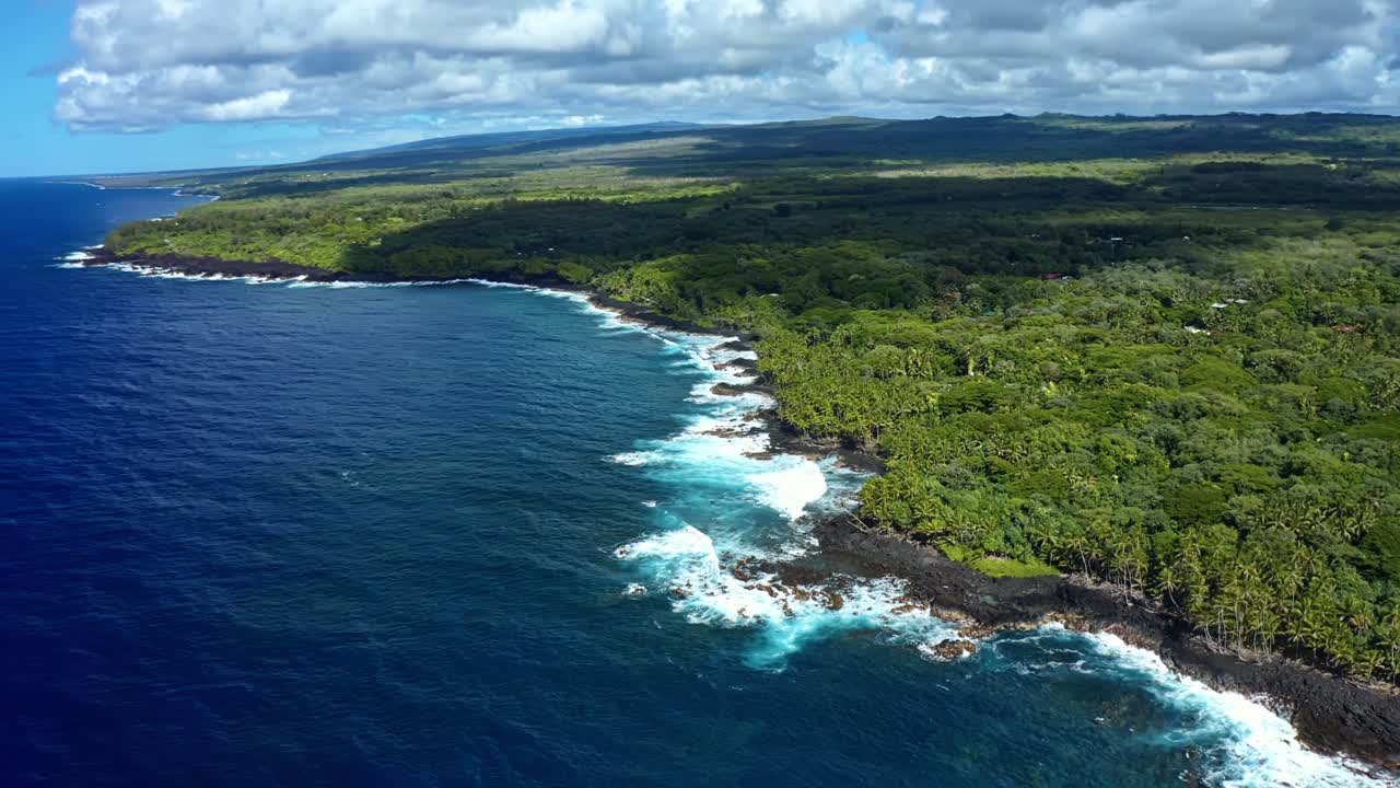 A breathtaking view of Hawaii’s wild coastline, where emerald rainforests spill into the deep blue Pacific — the island’s volcanic edges etched by waves and sunlight