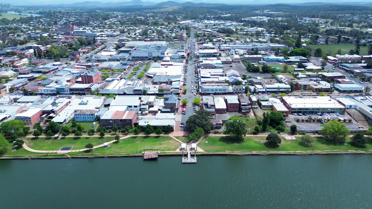 Drone aerial landscape of Manning River channel inlet with Taree main road urban downtown area including shop buildings residential streets and waterfront foreshore in Australia tourism infrastructure