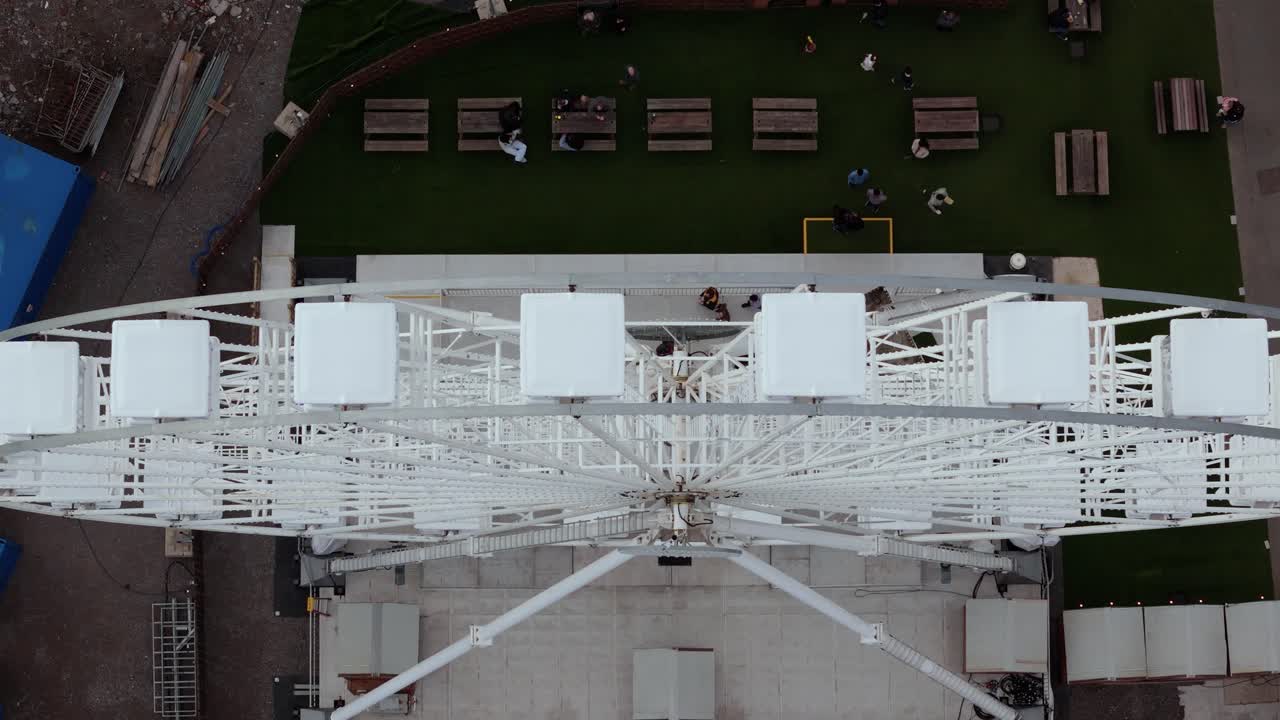 The Big Wheel spinning with tourists enjoying at Mumbles Pier Swansea in England. Aerial view.