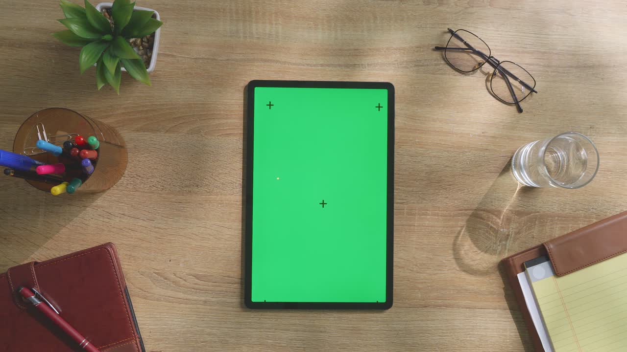 tableta de pantalla verde en un escritorio de madera