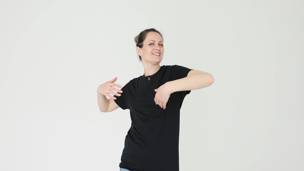A woman in a black t-shirt posing cheerfully on a white background