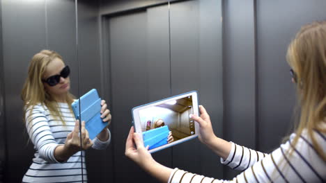 young woman with pad in the lift posing and taking pictures