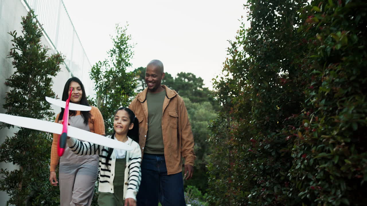 Family playing with toy airplane outdoors