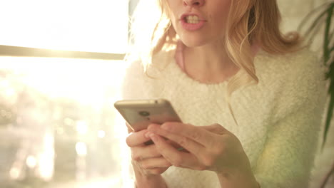 mujer sorprendida leyendo un mensaje en el teléfono. chica alegre con cara de sorpresa