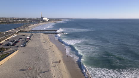 aerial view of a southern california beach with a power plant and coastline