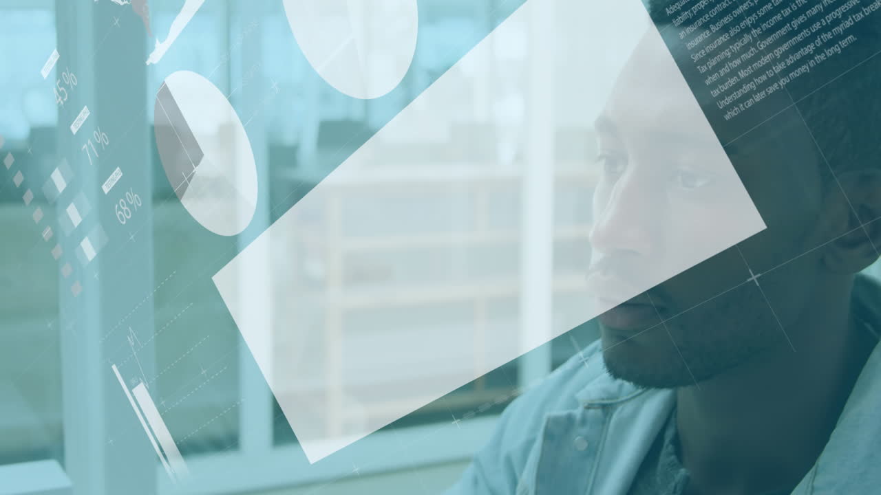 Animation of infographic interface over african american man working on computer in office