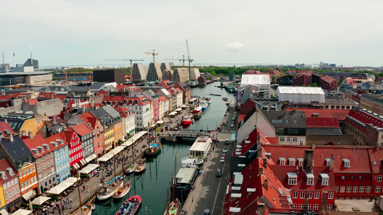 A straight-down aerial view of Nyhavn’s canal, showcasing docked boats and pedestrians along the quay.