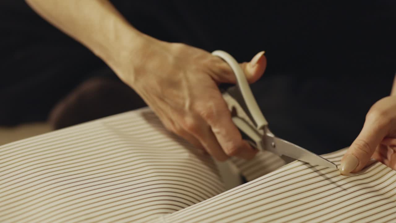 Handen knippen geribbeld inpakpapier met een schaar tijdens het voorbereiden van een kerstcadeau - Close-up