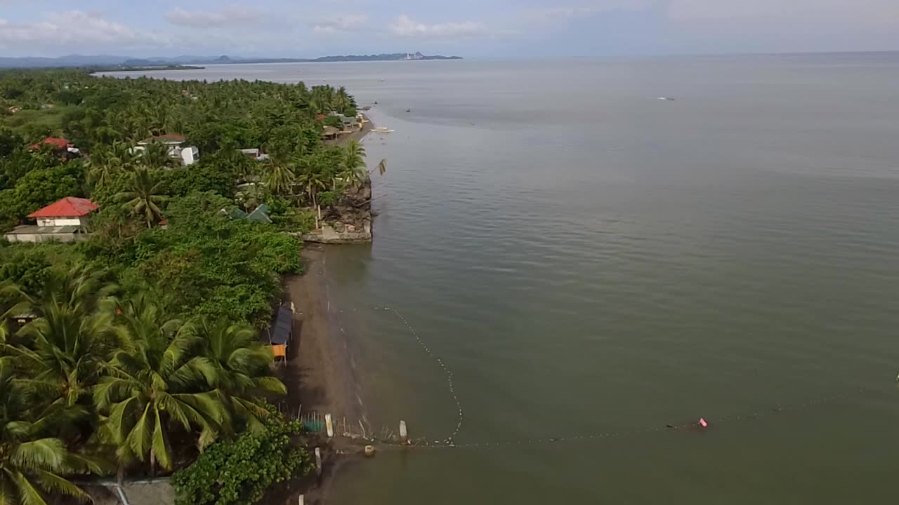 casas y establecimientos de asentamiento en la playa de arena y hermoso mar tranquilo en un día nublado, avión no tripulado aéreo