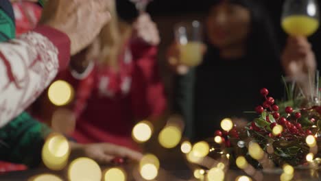 low angle shot of friends toasting their drinks during christmas celebrations