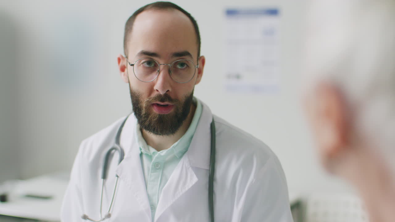 Dottore che parla con un paziente anziano durante la visita in clinica