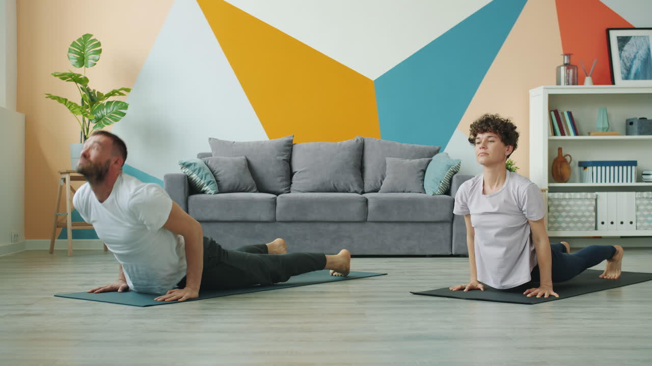 pareja practicando yoga en casa
