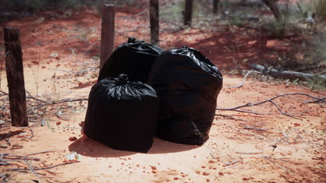 closeup of full trash bags on the sand