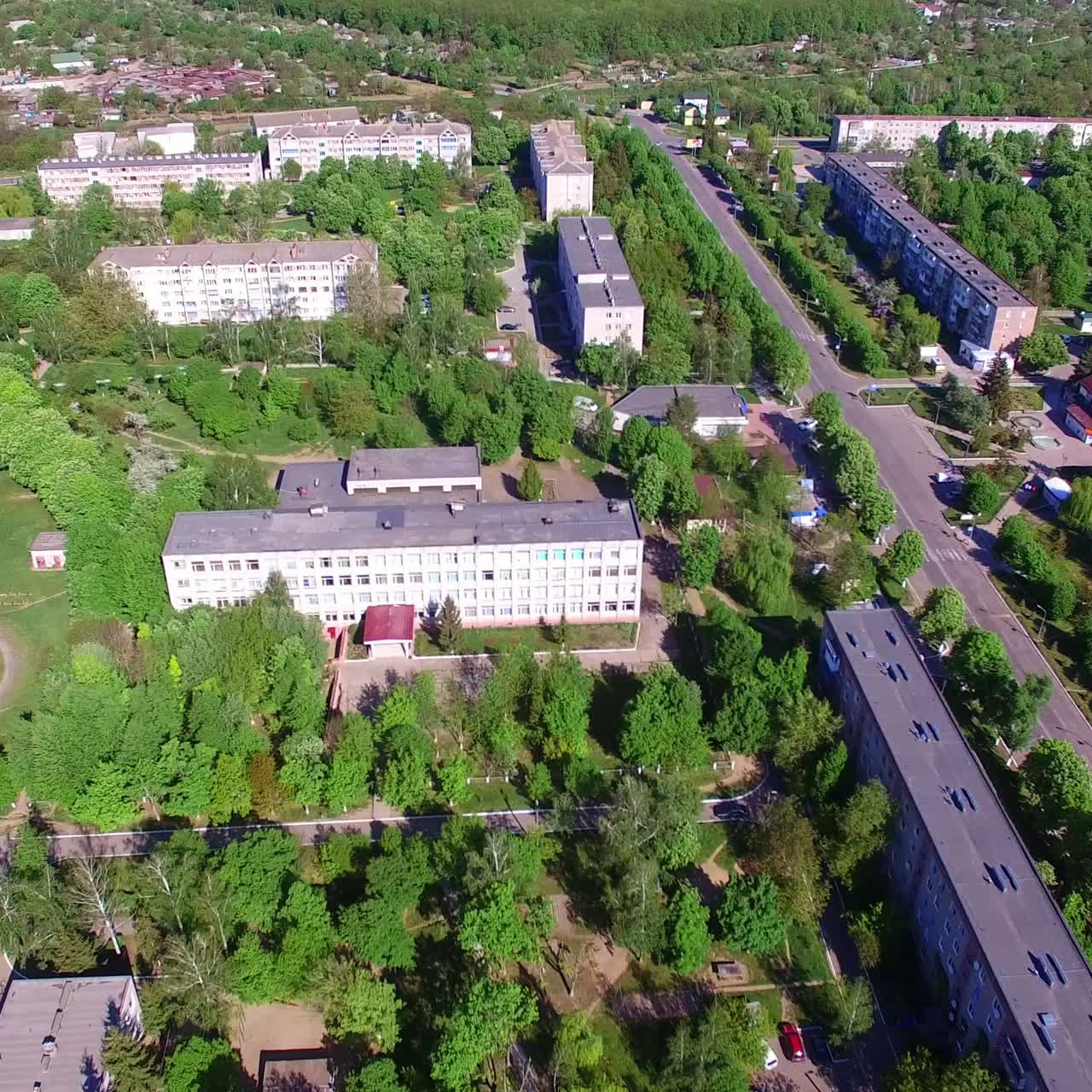 Blocks of flats built in rectangular and full of green trees. Aerial view on the residential areas on beautiful sunny day
