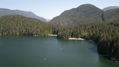 People-enjoying-white-sand-beach-at-Lake-Belcarra-Regional-Park,-stand-up-paddle-boards