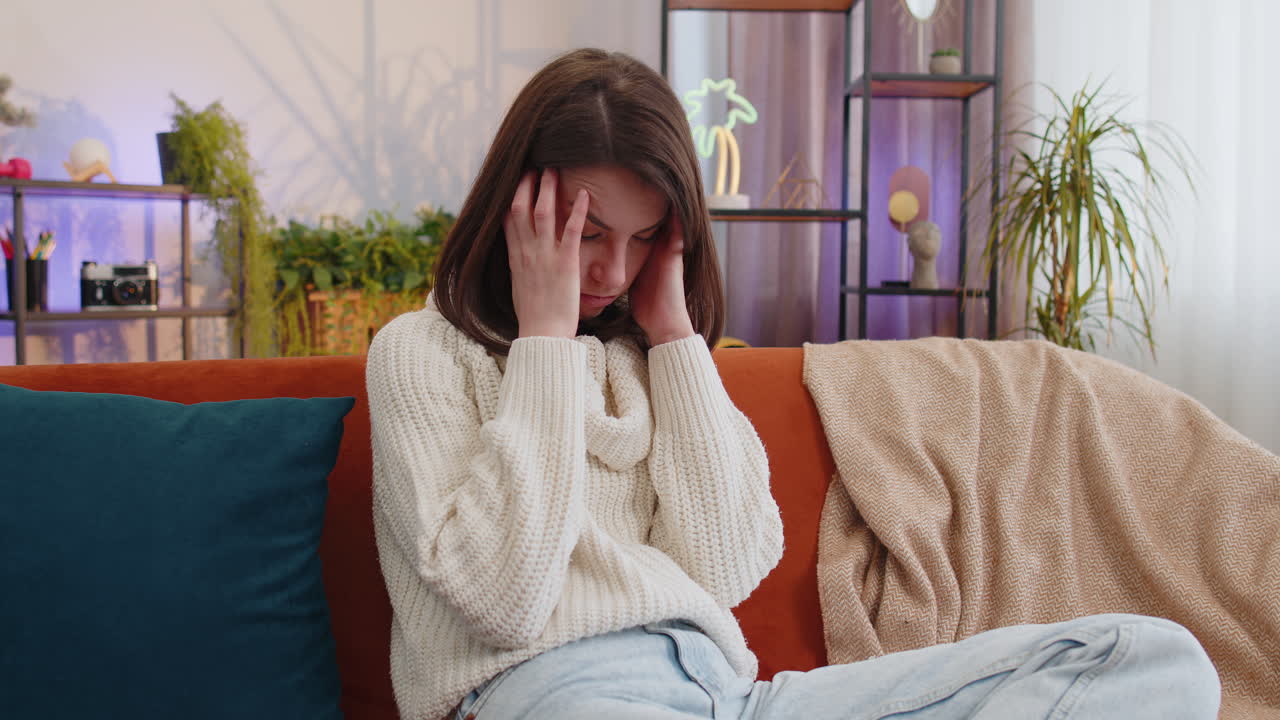 Displeased young woman rubbing temples to cure headache problem suffering from migraine stress