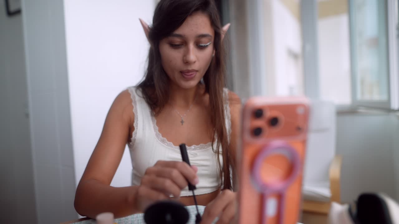 Young Woman with Elf Ears Applying Makeup for a Beauty Tutorial