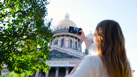 woman taking a photo of saint petersburg's cathedral