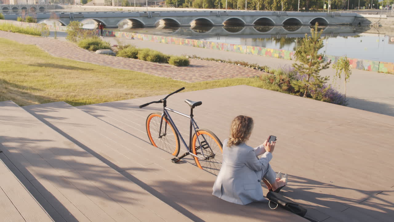 Businesswoman with Bike Sitting at Waterfront