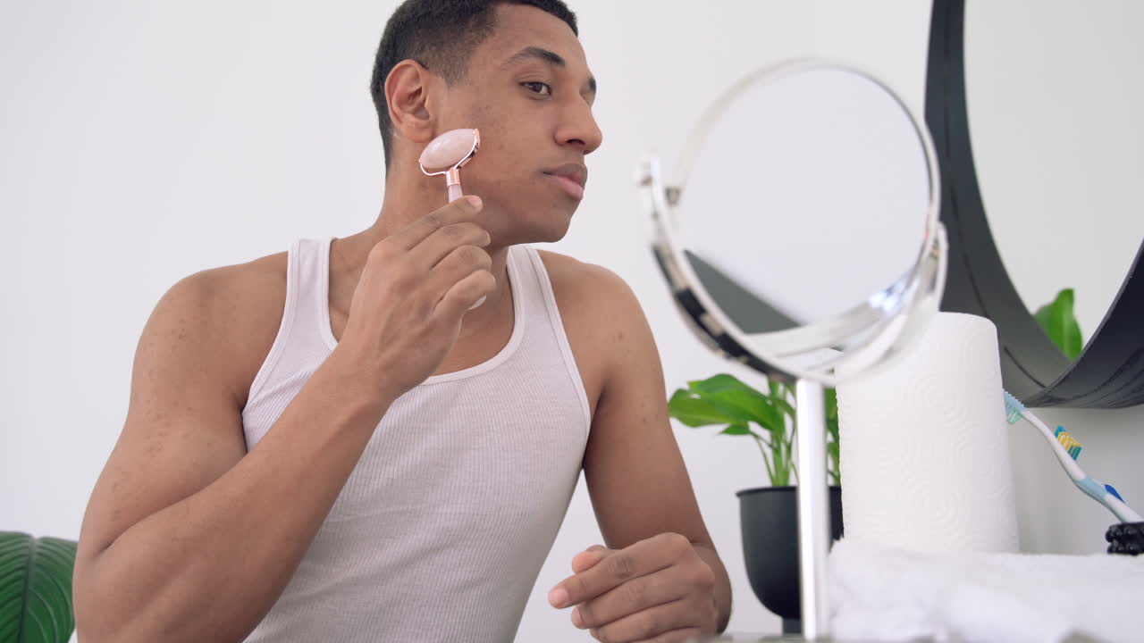 얼굴 마사지 기계 롤러 조각 도구를 사용하는 흑인 남성