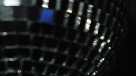 disco ball of silver color spinning slowly isolated on black background. concept. close up of a rotating ball with small mirror particles used for light effects in night clubs.