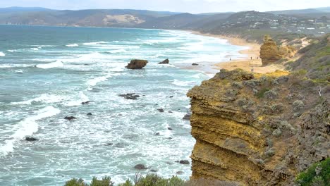 sweeping view of rugged cliffs and ocean waves under soft daylight at port campbell, australia. captures natural beauty and dynamic seascape