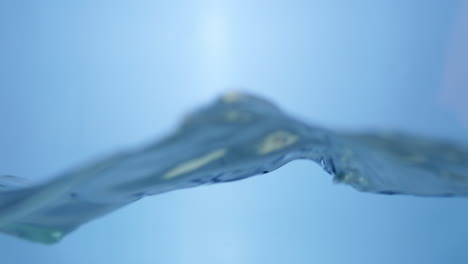 Waves-of-crystal-clear-blue-waters-splashing-and-sputtering-into-tiny-droplets-and-bubbles-of-clean-water