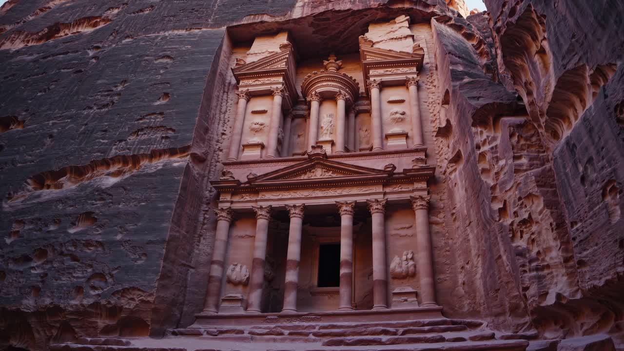 Low-angle video shot of ancient rock-carved architecture in a narrow canyon, capturing the grandeur