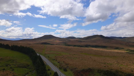 Wide-aerial-view-of-brown-plains-with-hills-in-Southland-region-of-New-Zealand