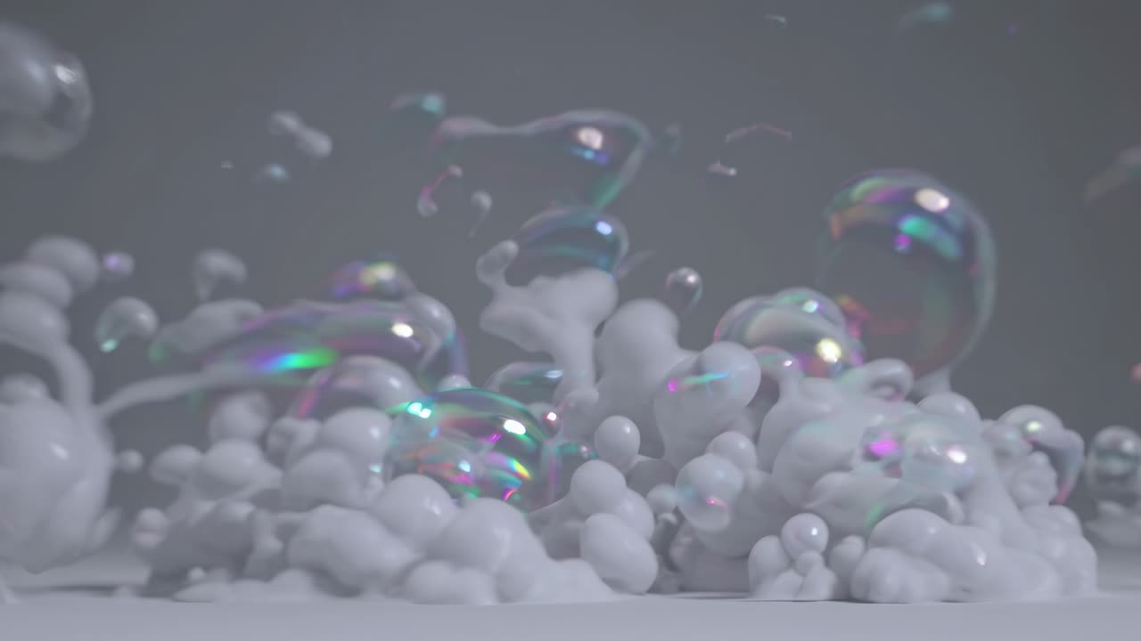 Abstract video of iridescent bubbles forming and merging in slow motion