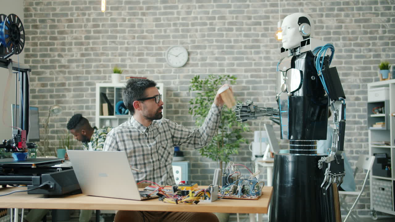 Robot assisting engineer in a modern tech office