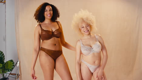 fotografía de estudio de dos amigas en ropa interior bailando y sonriendo promoviendo la positividad corporal