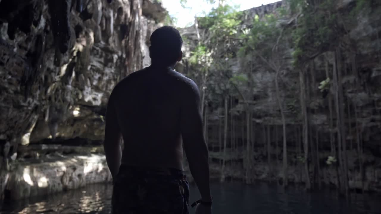 A man is seen on a natural cenote in the lush jungle surroundings of Tulum, Quintana Roo, Mexico