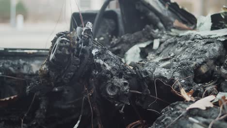 View-inside-charred-and-melted-car-destroyed-by-fire,-pan