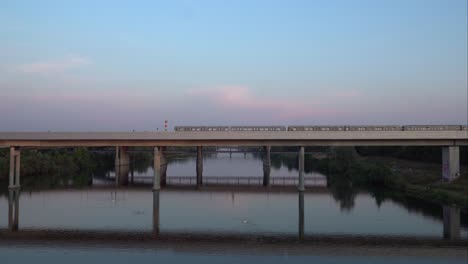 train passing on the railway bridge over the danube river on donauinsel in vienna, austria - wide shot
