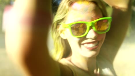 una foto de cerca de la cara de una chica cubierta de polvo de holi.