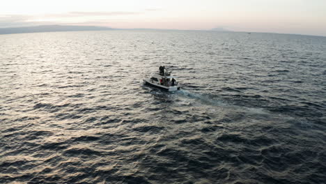 fishermen on motorboat sailing around adriatic sea fishing for tuna during early morning in croatia