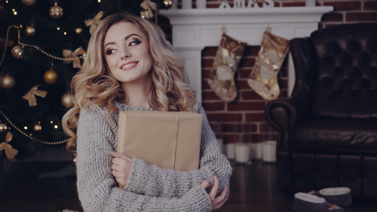 Beauty woman with christmas gift. Beautiful blonde woman with gifts at Christmas interior in room