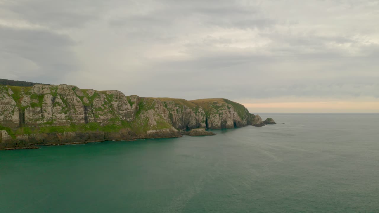 toma aérea distante en órbita de acantilados a lo largo de la costa en nueva zelanda