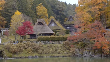 people walking in front of old japanese houses in the town of shirakawago japan