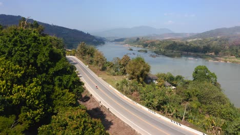 Motorcycle-Driving-On-Rural-Road-Near-Mekong-River,-Golden-Triangle,-East-Asia