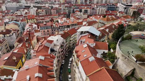 drone shot flying and turning over a curved street in lisbon