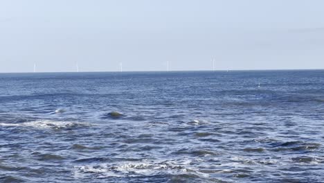 wind turbines in the distance in the north sea - taken off the north east coastline at whitley bay (north tyneside, uk)