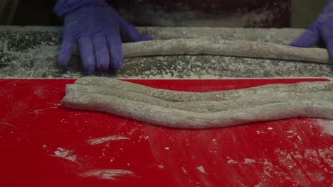 Hand-rolling-the-taro-dough-into-cylindrical-shapes,-night-market-vendor-making-popular-Taro-balls-dessert,-close-up-shot