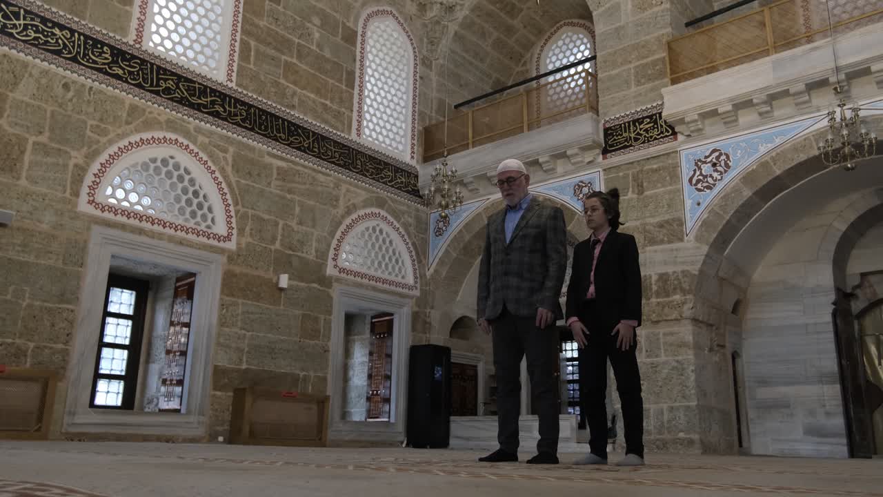 Nonno e nipote che pregano in moschea